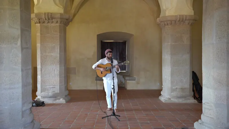 Yuval Gilboa playing guitar under the stone arches of a medieval Portuguese fortress